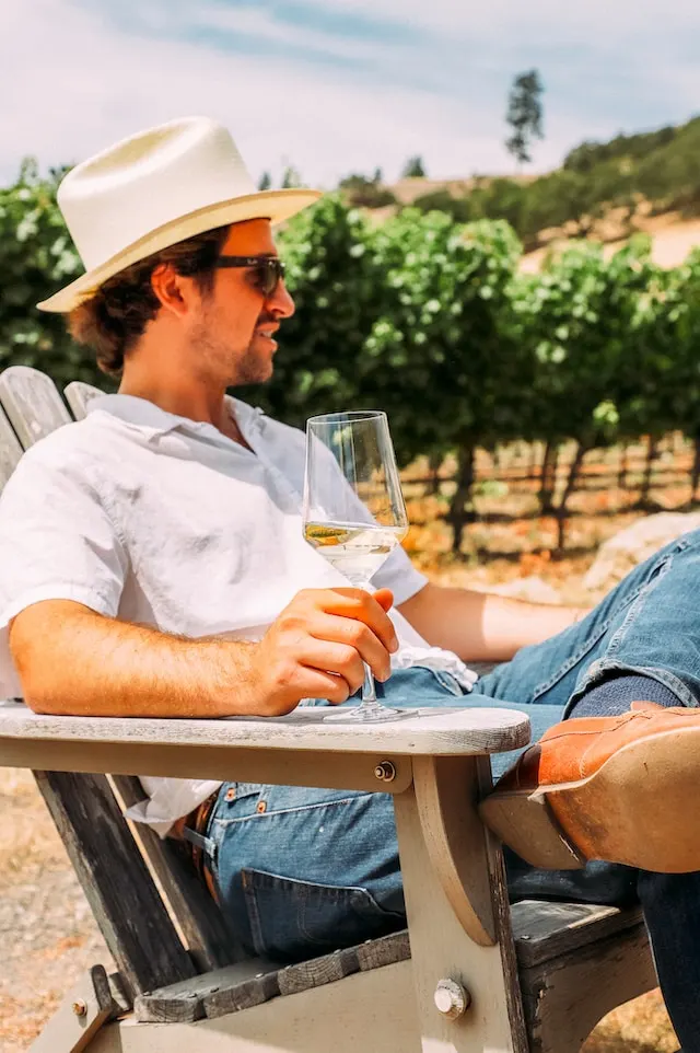 Man drinking wine on a chair in a vineyard